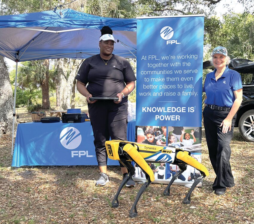 Mariota Theodoris, Project Manager/STEM Sport Coach from Florida Power and Light demonstrated FPL’s robot dog “Spot” and shared the benefits of using robots at FPL facilities. Pictured are Mariola Theodoris, Jennifer Huber and  “Spot”. [Photo by Margaret Englund]