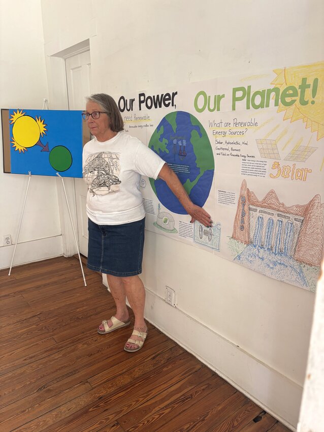 Becky Rhodes with 2025 Earth Day theme mural. [Photo courtesy Margaret England]