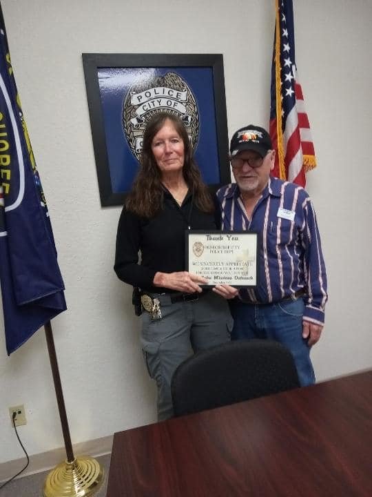 Okeechobee City Police Detective Bettye Taylor presents a certificate of appreciate to Bruce Swinford.