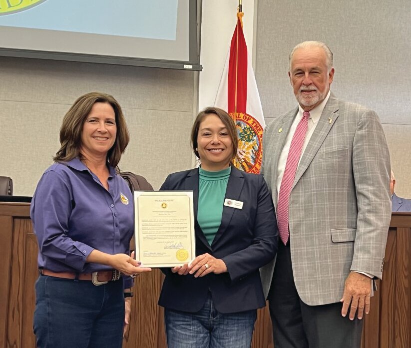 OKEECHOBEE -- (Left to right) Robbi Sumner and Audrey Kuipers to accept the National Association of Conservation Districts Stewardship Week Proclamation from Commissioner Terry Burroughs at the April 27 meeting of the Okeechobee County Commission.