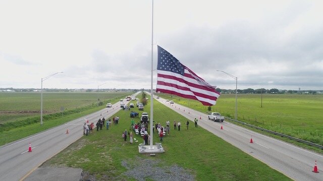 Clewiston's new gateway flag was celebrated Memorial Day at its new home on US 27, first being raised to the top of the mast, then brought to half-mast until noon, when it was raised to full-mast again.
