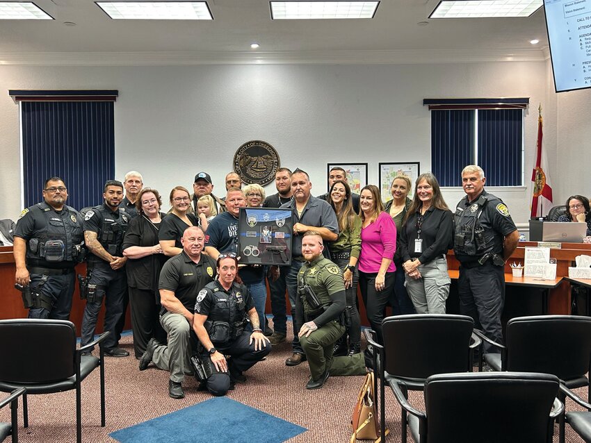 Family, coworkers and friends of Officer Jason Chapman are pictured at a recent city council meeting. The family was gifted a shadow box in memory of Chapman, who was killed in a car accident.