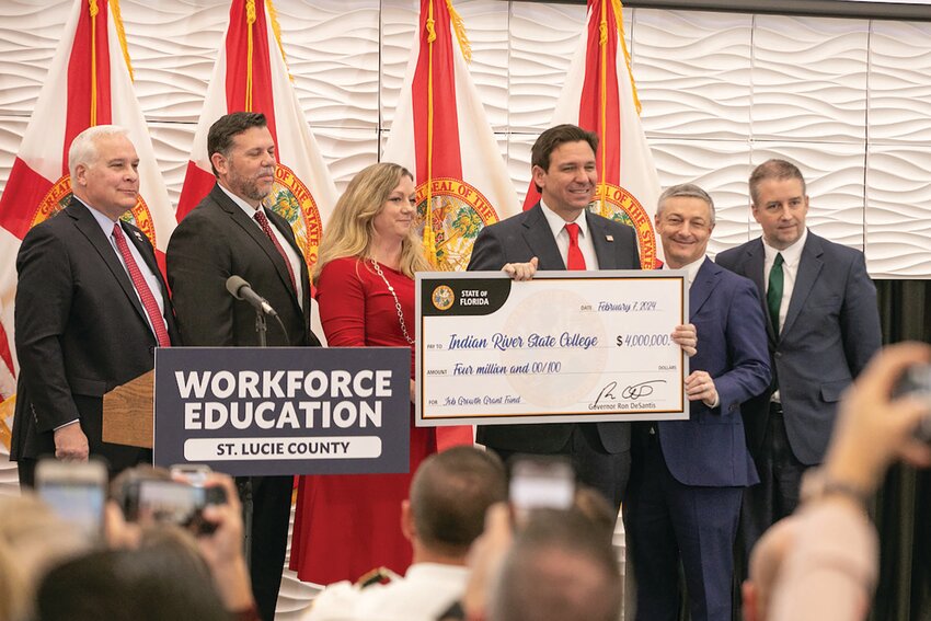President Timothy Moore and District Board of Trustees Chair Tony George accept an oversized check from Governor DeSantis. Joining them onstage were Florida Secretary of Commerce J. Alex Kelly and representatives from Diamond Defense Systems. [Photo by James Crocco/IRSC]