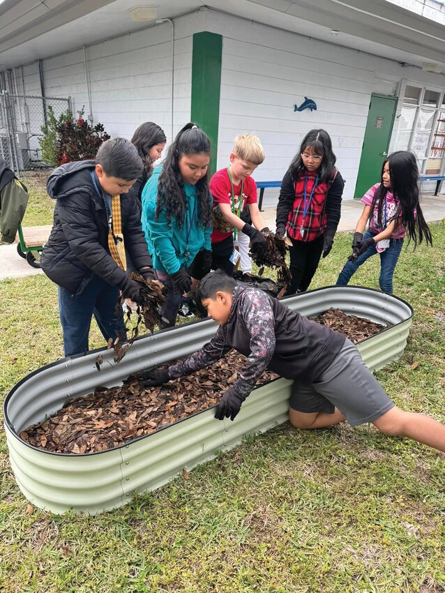 LABELLE -- Ace Hardware in LaBelle recently donated plants and seeds to help  teacher Jill Strickland, Deputy Bozzi and third grade students to plant a garden. The store also gave the school a discount on bags of soil. [Photo courtesy LaBelle Elementary School]