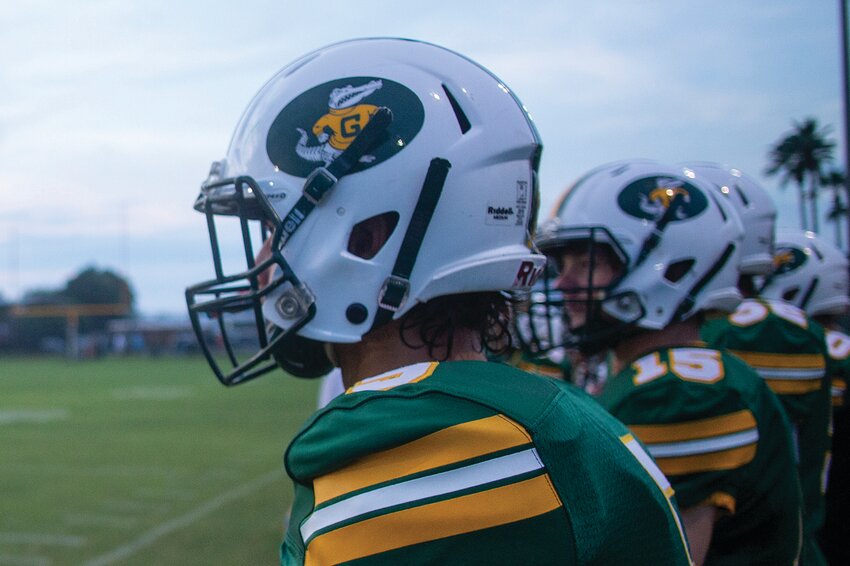 A few Gators watch from the sideline, waiting to take the field. [Photo by Richard Marion/Lake Okeechobee News]