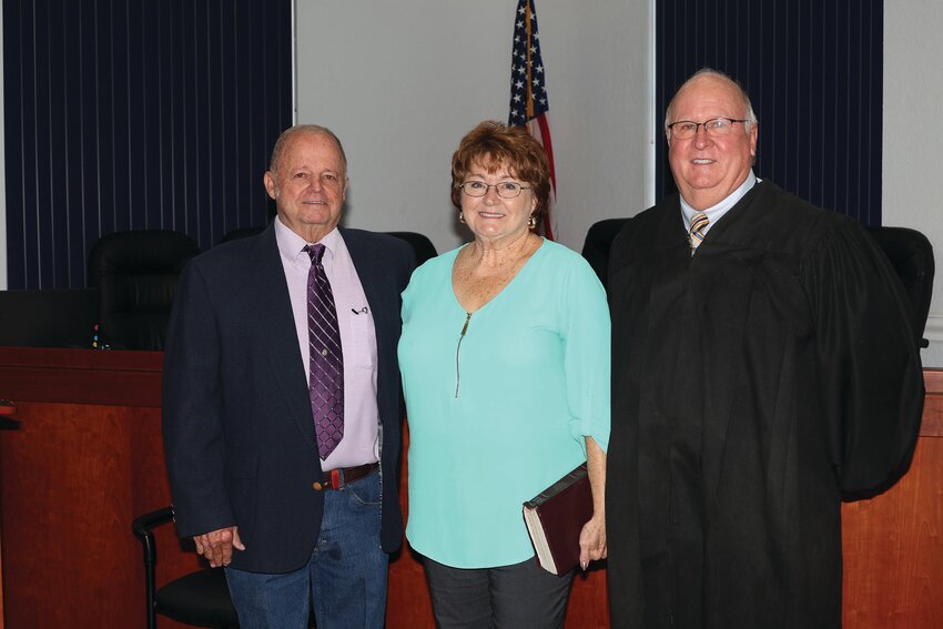 Noel Chandler is sworn in as a city council member. He is beginning his 20th year on the council. Pictured with him are Judge William Wallace and Chandler's wife Louise..[Photo by Sandra Pearce]