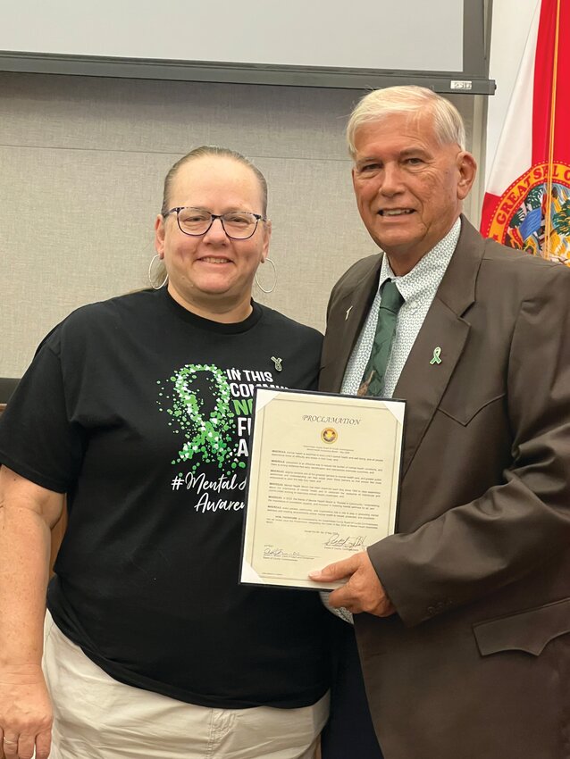 OKEECHOBEE -- Leah Suarez of Our Village (left) accepted the proclamation for Mental Health Awareness Month from County Commission Chairman David Hazellief at the May 8 meeting of the Okeechobee County Commission. [Photo by Katrina Elsken/Lake Okeechobee News]