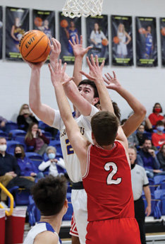 Bryce Baird is challenged on a shot by two Cave City defenders.