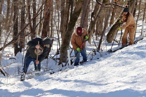 Tanner Caston, Delvin Freeman and Cindy Gentry were among more than a dozen individuals who worked to clear snow from the nearly five miles of lines at Fifty Six Friday so that sunlight could help the thawing process.