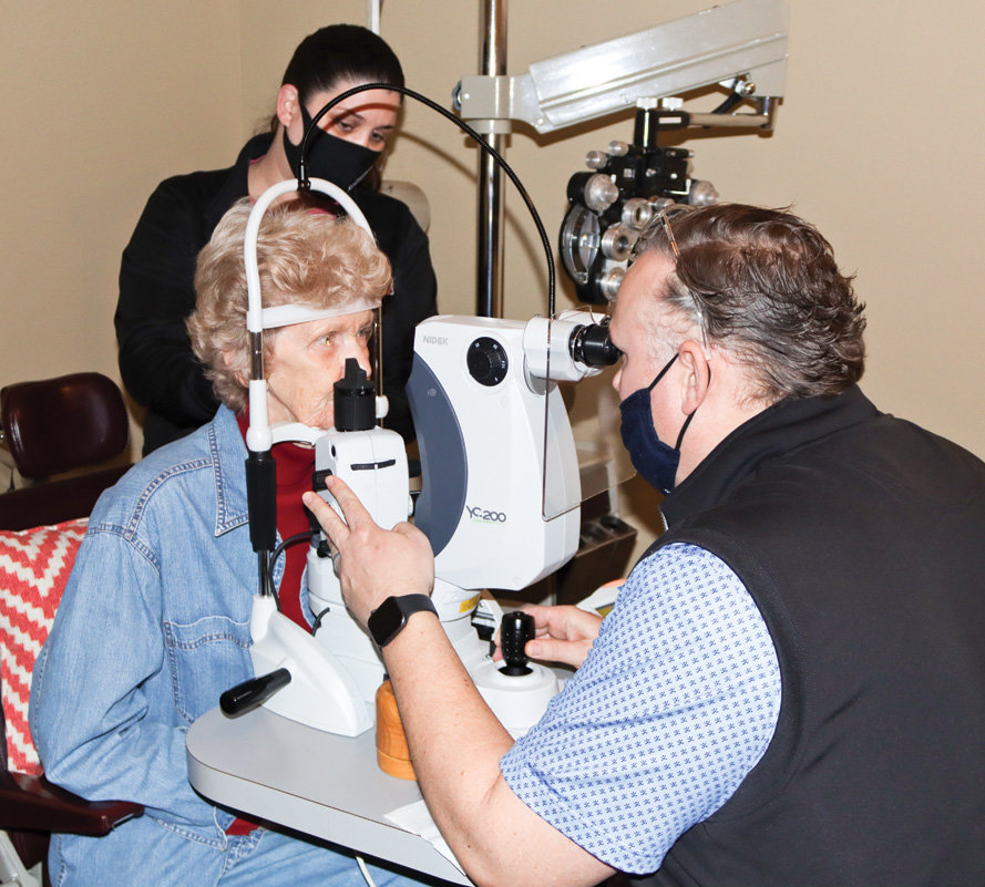 Dr. Chris Deitrick prepares to treat patient Geraldene Sutton with the YAG capsulotomy to improve her vision. She had cataract surgery about three years ago. Lisa Johnson, optometric technician, assists.
