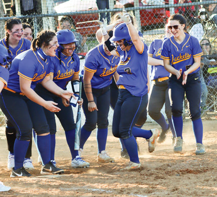 Kylie Minick is celebrated by teammates as she approaches homeplate after hitting a three-run homer during the March 29 game against Harding Academy.