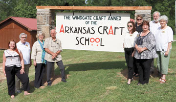Arkansas Craft School Executive Director Rachel Reynolds, at left, with board members (from left) David Ciscel, Gin Brown, Stan Brown, Maegon Mayes, Lynn Nancarrow, Dorothy Lanning, Bud Thurman and Joy Harp at the annex location. The sign is an art piece in progress.