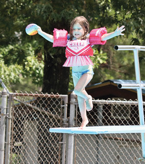 A young swimmer takes her turn from the diving board at the public swimming pool June 25.