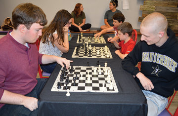 In foreground, Nate Franks and Will Fowlkes are among those participating in Chess Night at the Stone County Community Center.