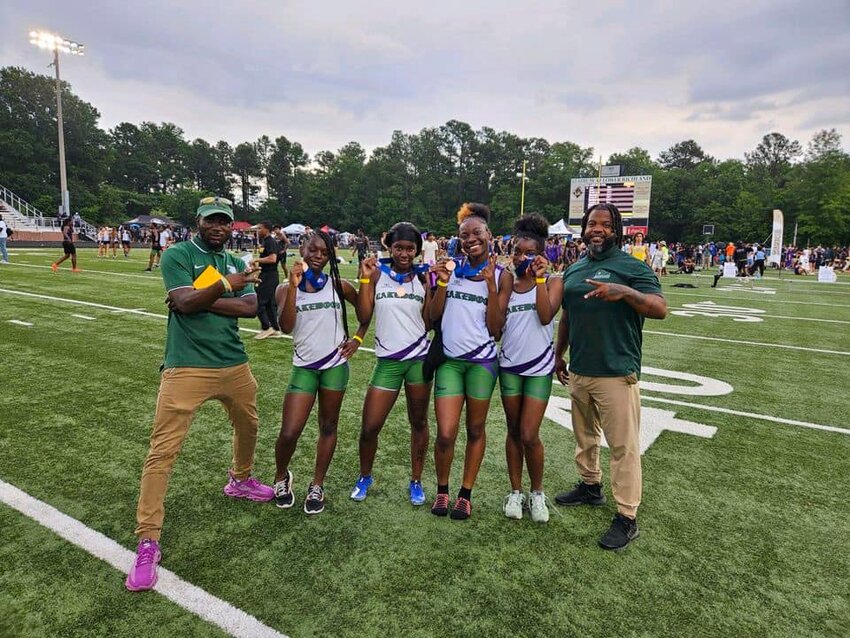 Lakewood's girls 4x100 team celebrates with head coach Youshi Kirkland, left, and assistant coach Anwond Boykin, right, after setting a school record at the SCHSL 3A state meet on Friday.