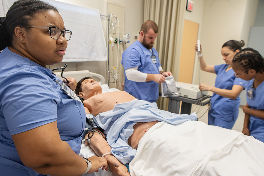 Photo provided  CCTC nursing students check vital signs using simulation equipment.