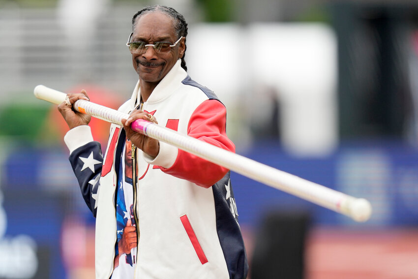 Snoop Dogg gets a pole vaulting lesson during the U.S. Track and Field Olympic Team Trials on June 23, 2024, in Eugene, Ore. Snoop will be one of the final torchbearers of the Olympic flame ahead of the Games&rsquo; opening ceremony Friday, July 26.