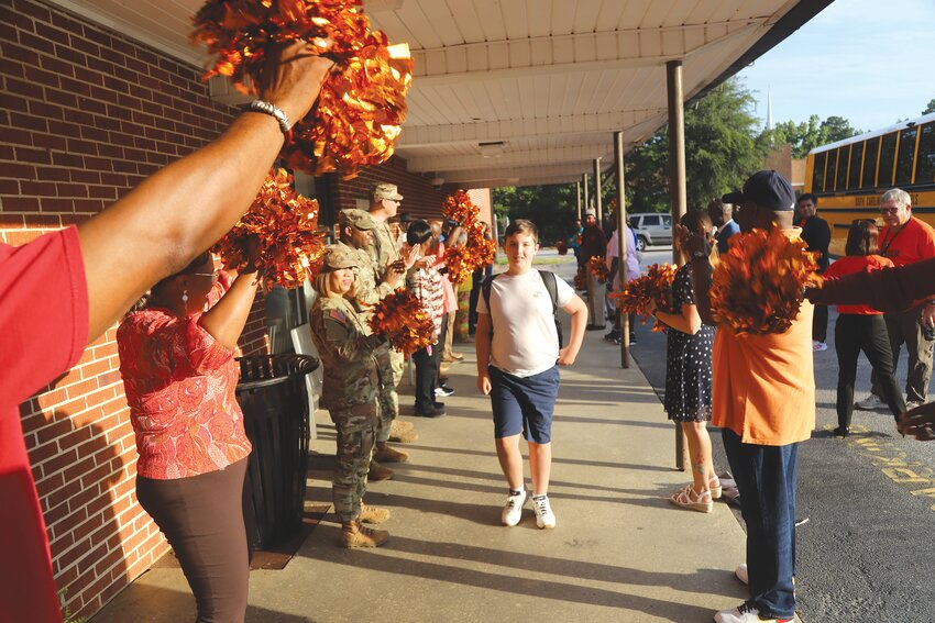 Ebenezer Middle School students enter the school Thursday morning to cheers from community members who showed up to greet them for the first day of school in Sumter School District.