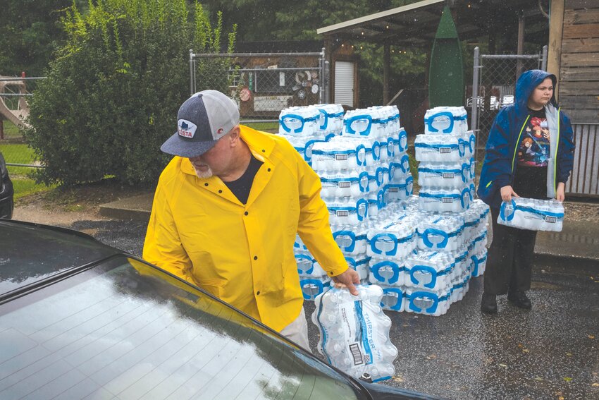 Scott Estep puts a case of water in a car in the parking lot of The Palmetto Oyster House. Po' House and J. O' Gradys co-owners Estep and Kevin Collins have been giving out free water (and sometimes free meals) during storms and other events like COVID-19 for years and continued the practice in preparation for tropical storm Debby.