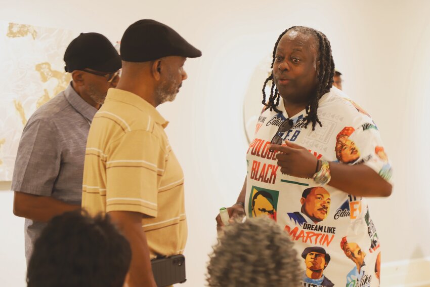 Kevin Cole attends the opening of his &quot;Where Do We Go From Here? Gerrymandering and Voting&quot; exhibit at Sumter County Gallery of Art on Aug. 29 and talks with attendees about the symbolism of his artwork. Cole will visit the gallery in October for his artist talk.