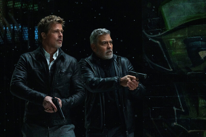 This image released by Apple TV+ shows Brad Pitt, left, and George Clooney in a scene from &quot;Wolfs.&quot;