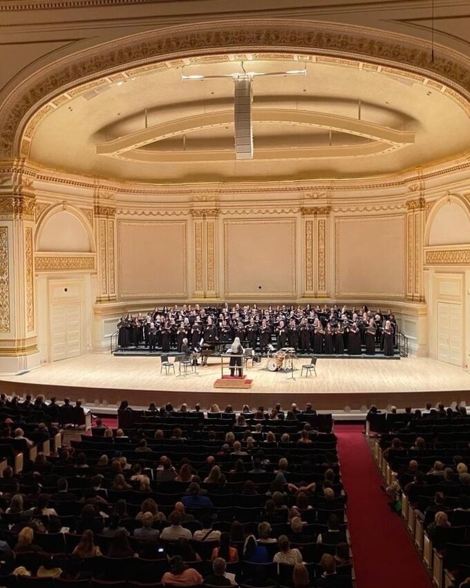 Sonja Sepulveda leads a chorus of singers at Carnegie Hall.