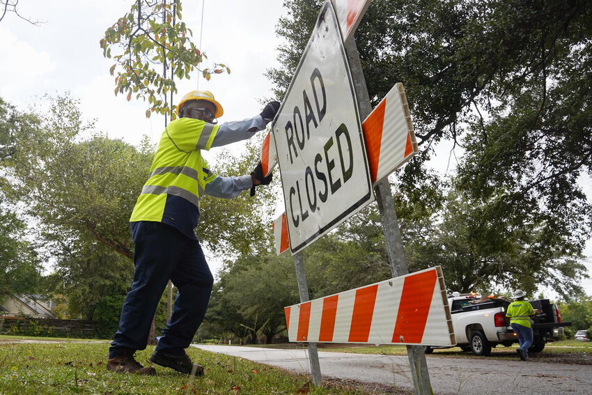 ADAM FLASH / THE SUMTER ITEM    Hurricane Helene passed through Sumter on Thursday, Sept. 26 as crews worked to repair the damage the following morning, Friday, Sept. 27. SCDOT worker Alfonso Green, with the help of Melinda Johnson, cleans up &lsquo;Road Closed&rsquo; signs.