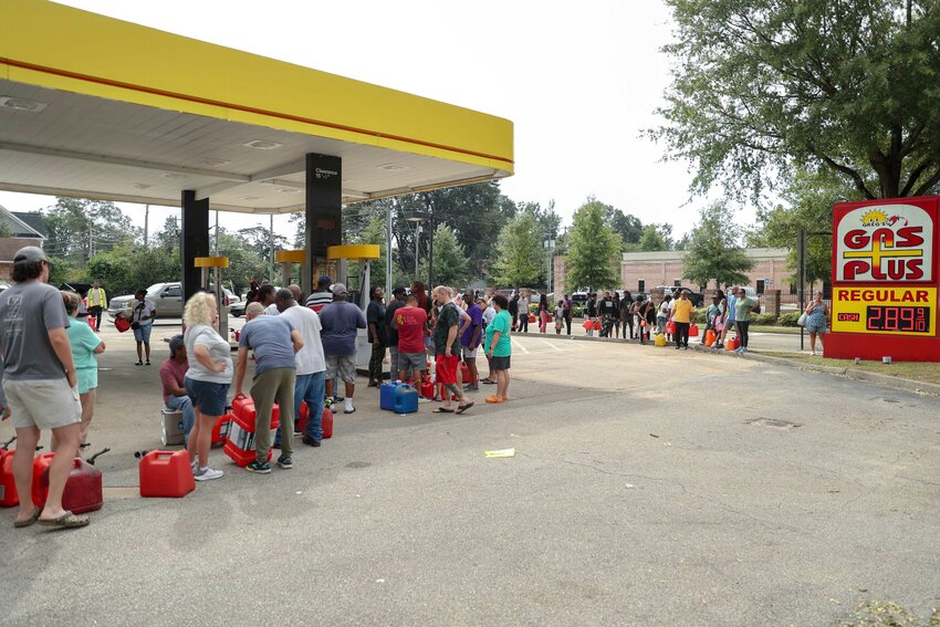 Residents wait in line with gas cans at a Gas Plus gas station in the aftermath of Hurricane Helene Sunday, Sept. 29, 2024, in North Augusta, S.C.