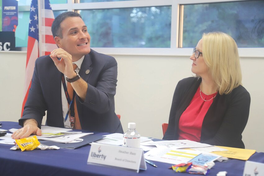 Liberty STEAM Charter School Executive Director Trevor Ivey, left, shares a point during Monday's board of directors' meeting at the school's Primary Academy as Heather Bass looks on.