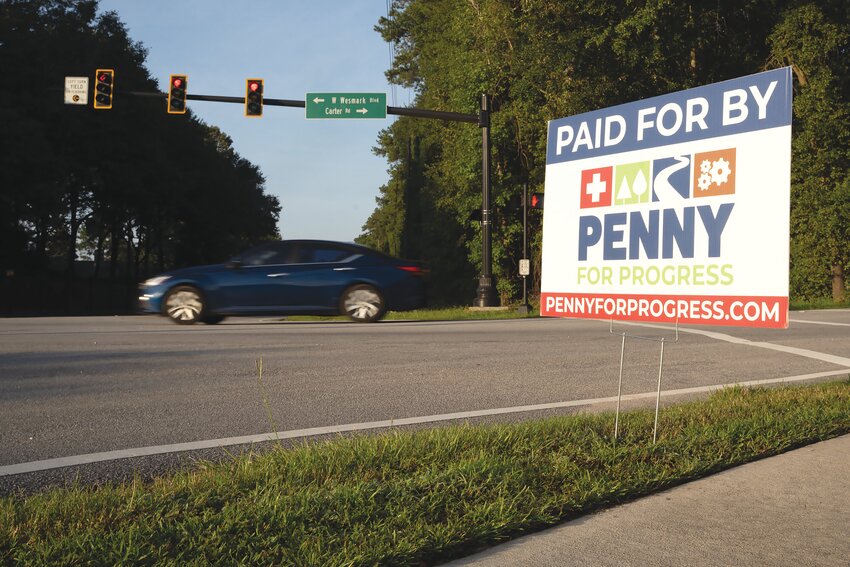 A &quot;Paid for by Penny for Progress&quot; sign stands at the intersection of Wilson Hall Road and Carter Road, among many other places in town.