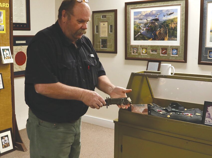VFW Post 3096 Commander Chris McCormick shows a bayonet that was torn by a bullet in the Vietnam War. This and other pieces of history from the Vietnam War will be on display at an event on March 29 at Lee County Veterans Museum that will commemorate local Vietnam veterans.