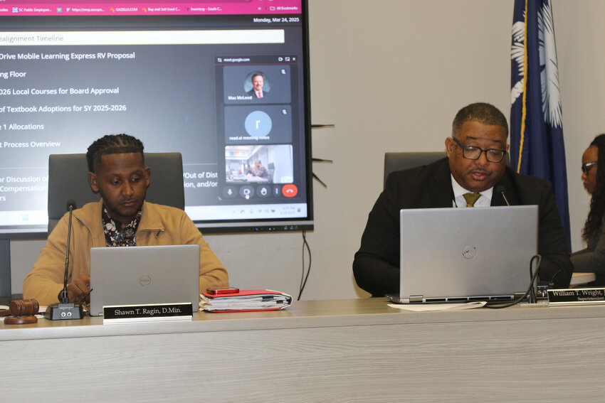 Sumter school board Chairman Shawn Ragin, left, listens Monday night as Superintendent William Wright Jr. discusses his proposed timeline for realignment at the district's Board of Trustees' meeting at the district office, 1345 Wilson Hall Road.