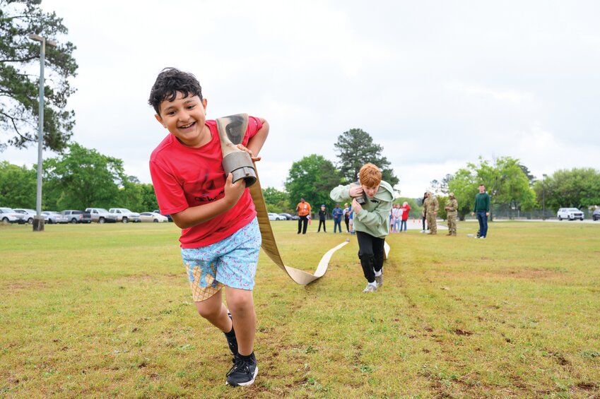 Elijah Ramirez, left, a fourth-grade student at High Hills Elementary School, pulls a fire hose in a race. The activity was part of High Hills Elementary School's Earth Day celebration on Friday, April 11, 2025. 