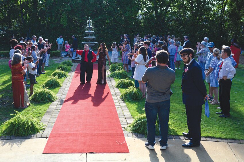 Zen Hollywood, left, walks with an escort down the red carpet at Sumter Joy Prom. Sumter County Sheriff's Office held the prom at The O'Donnell House in Sumter on Friday, May 9.