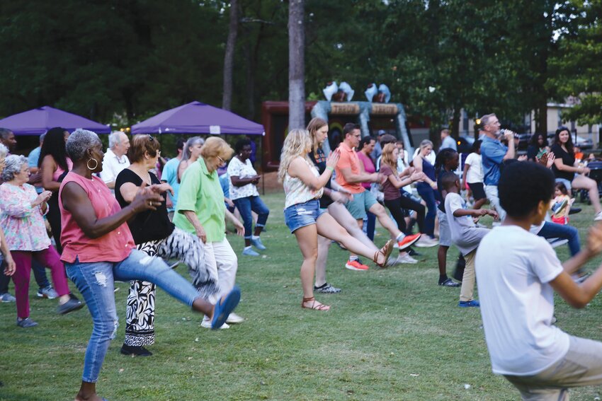 Attendees at a Taste at the Gardens learn a new line dance from DJ Howie D.