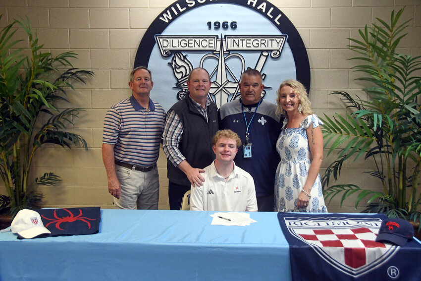 Wilson Hall's Jackson Bonser, center, is surrounded by family and coaches after signing to continue his football career at the University of Richmond on Tuesday.