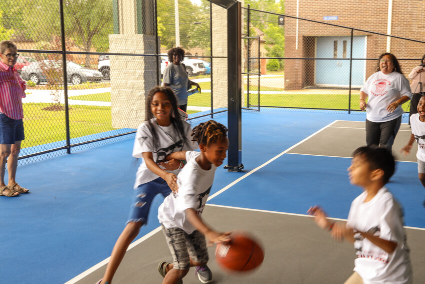 Community members try out the new basketball court at South Sumter Park following its ribbon cutting on June 10.