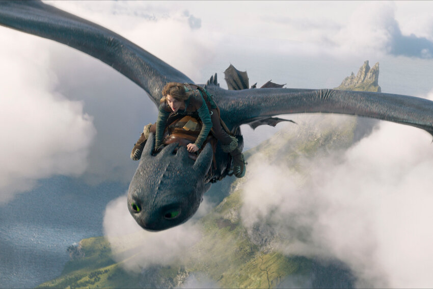 This image released by Universal Pictures shows Mason Thames, as Hiccup, riding Night Fury dragon, Toothless in a scene from &quot;How to Train Your Dragon.&quot;
