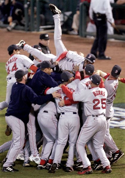 Boston Red Sox Pokey Reese jumps on top of his teammates after the Red Sox defeated the St. Louis Caridnals 3-0 in Game 4 to win the World Series at Busch Stadium in St. Louis, Wednesday, Oct. 27, 2004.