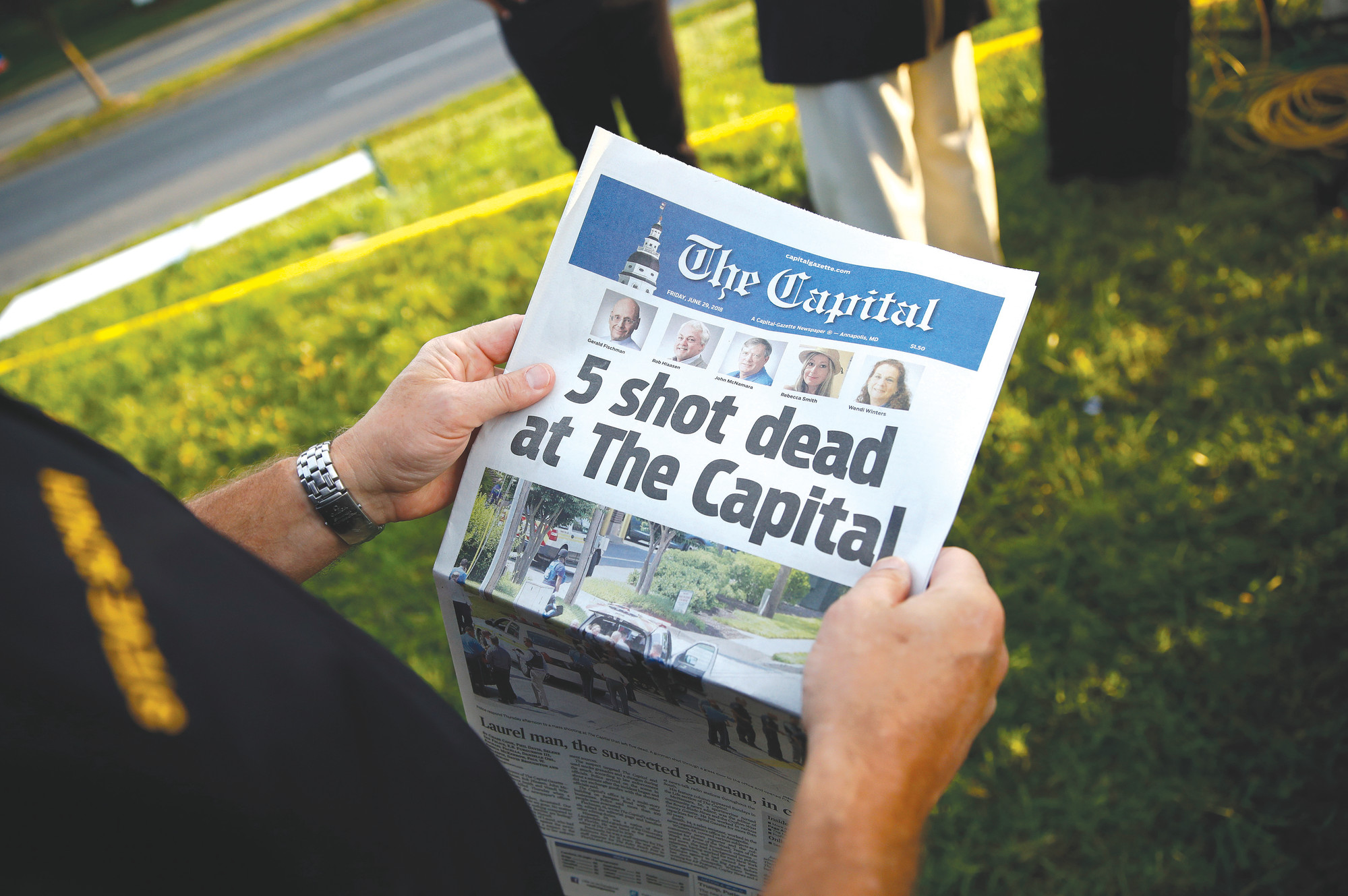 Steve Schuh, county executive of Anne Arundel County, holds a copy of The Capital Gazette near the scene of a shooting at the newspaper's office Friday in Annapolis, Maryland. A man armed with smoke grenades and a shotgun attacked journalists in the building Thursday, killing several people before police quickly stormed the building and arrested him, police and witnesses said.