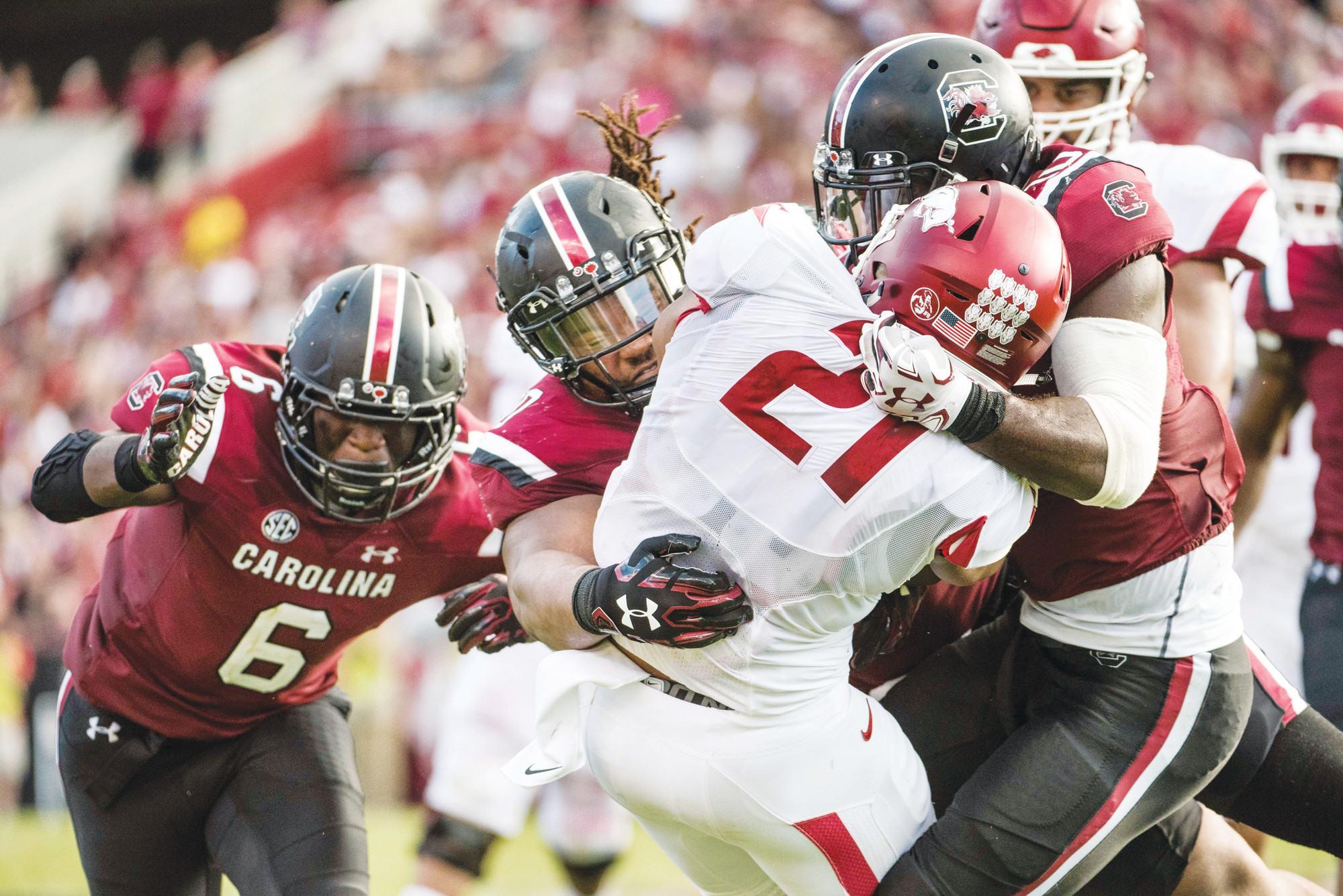 Three South Carolina defenders take down Arkansas running back Devwah Whaley (21) last season. Gamecock head coach Will Muschamp is looking for improvement from his team this season after going 9-4 last year.