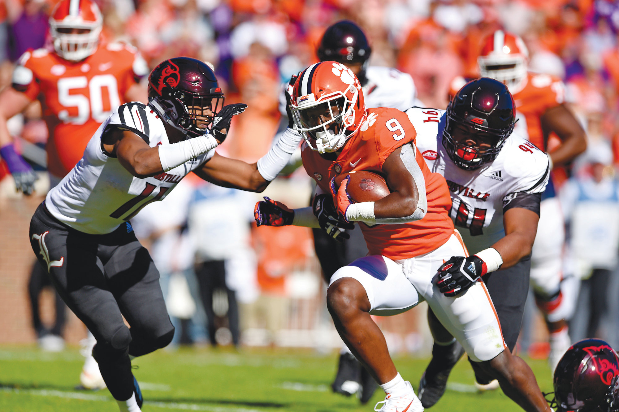 Clemson's Travis Etienne rushes through Louisville's Dee Smith (11) and G.G. Robinson to score a touchdown during the first half of an NCAA college football game Saturday, Nov. 3, 2018, in Clemson, S.C. (AP Photo/Richard Shiro)