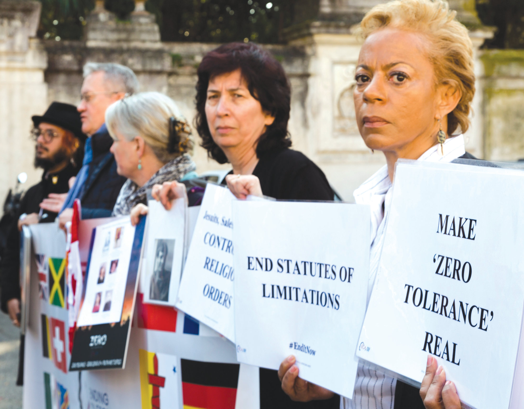 Psychoneurologist and founding member of the Ending Clergy Abuse organization Denise Buchanan, right, and member Leona Huggins, second from right, participate in a protest outside the St. Anselm on the Aventine Benedictine complex in Rome on the second day of a summit called by Pope Francis at the Vatican on sex abuse in the Catholic Church on Friday. Pope Francis has issued 21 proposals to stem the clergy sex abuse around the world, calling for specific protocols to handle