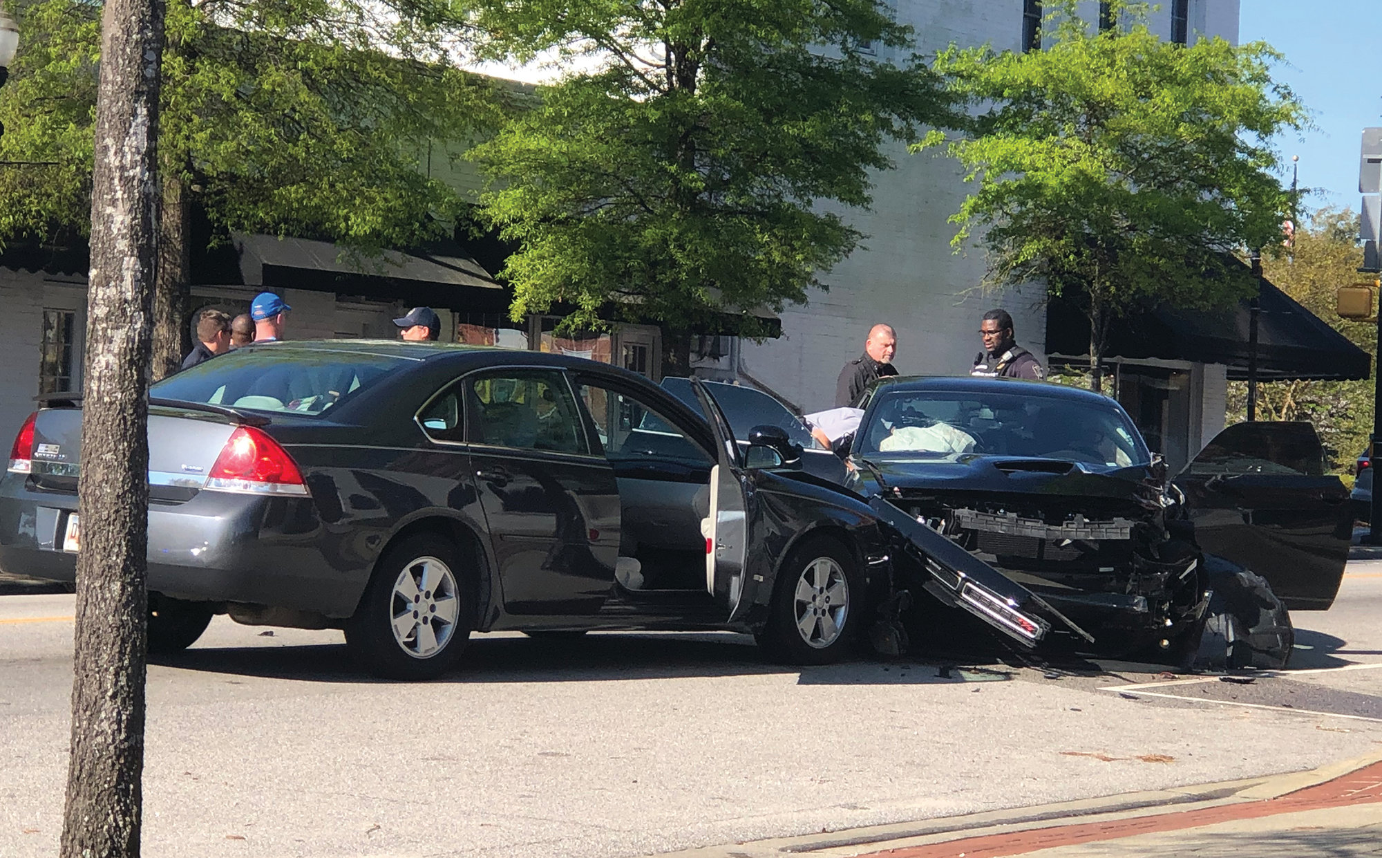 SHARRON HALEY / SPECIAL   TO THE SUMTER ITEMSummerton Police Chief Ray Perdue, second from right, looks over the vehicle involved in a chase that began in Summerton and ended in downtown Manning. Two Charleston men fled the scene of the wreck but were immediately apprehended.