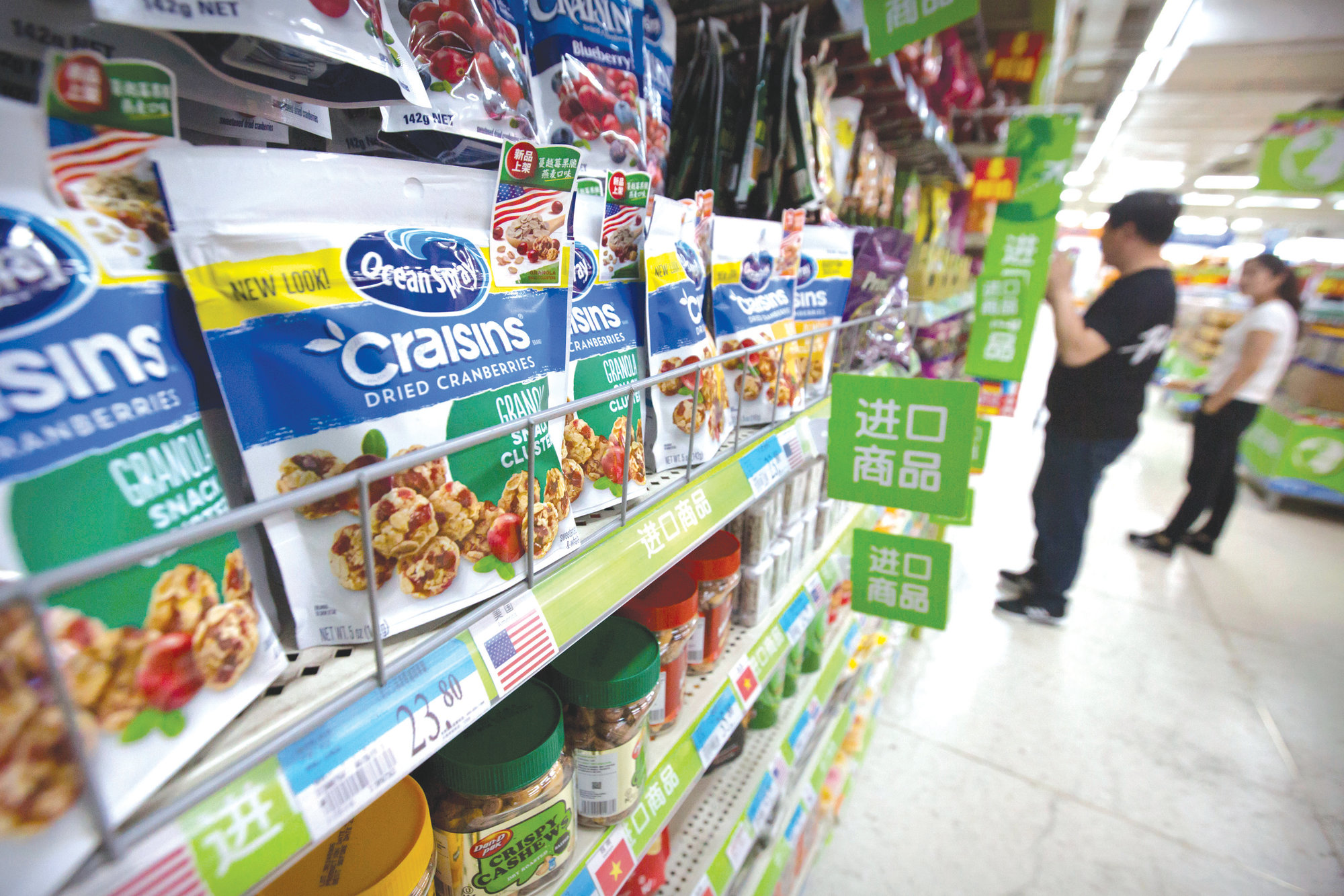 Customers shop near dried cranberry products from the United States at a supermarket in Beijing on Tuesday. Sending Wall Street into a slide, China announced higher tariffs Monday on $60 billion worth of American goods in retaliation for President Donald Trump's latest penalties on Chinese products.