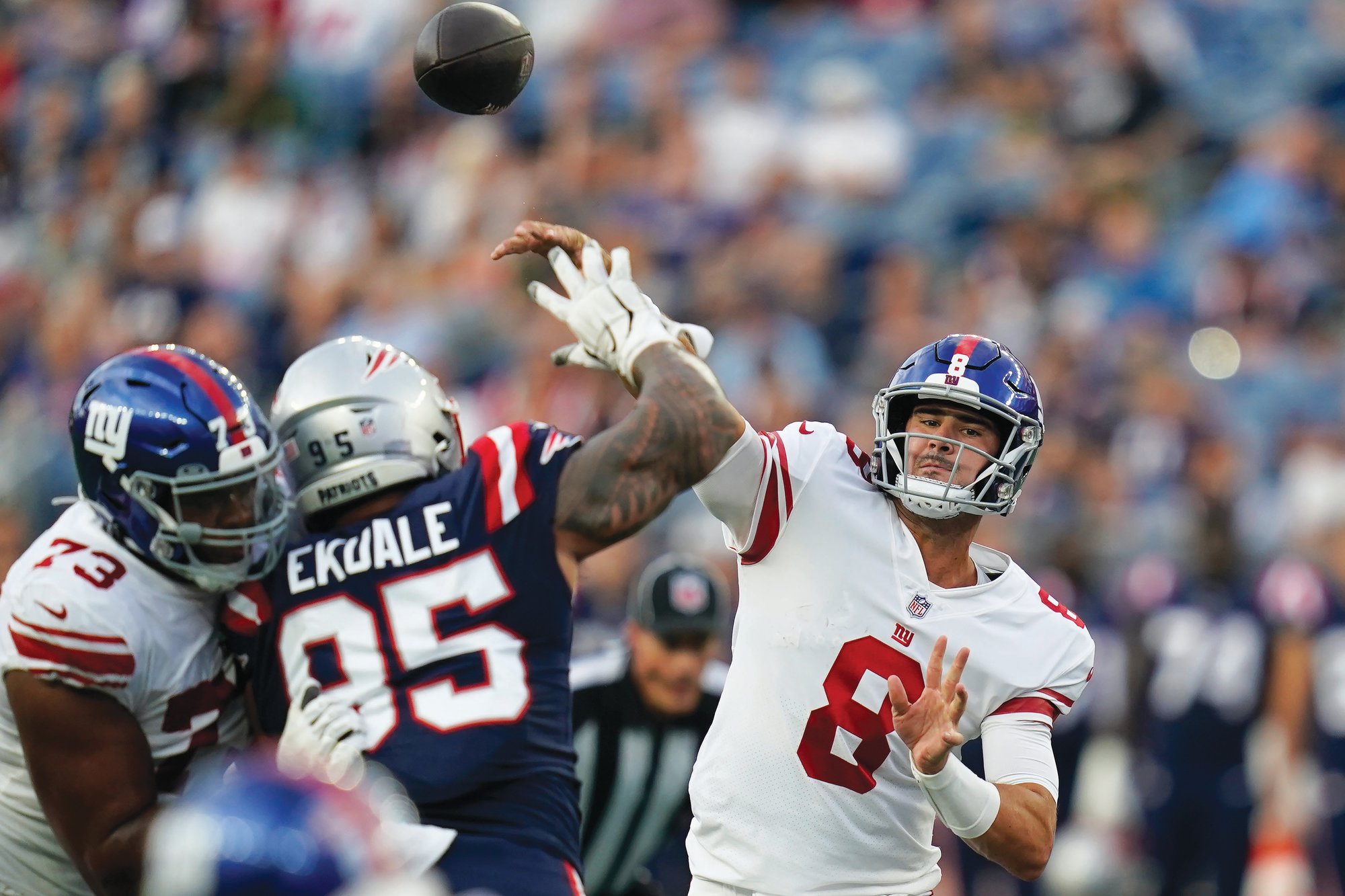 New York Giants quarterback Daniel Jones (8) throws a pass over New England Patriots defensive tackle Daniel Ekuale (95) on Thursday in Foxborough, Massachusetts.