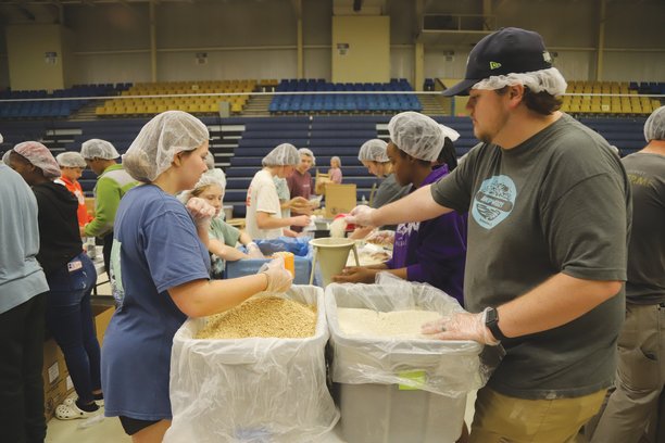 Youth volunteers from area churches help prepare meals for overseas Saturday at "One Weekend" at Sumter County Civic Center.