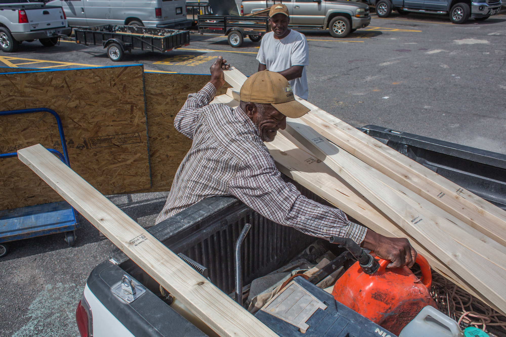 Anthony and Jack Bracey load lumber they bought for additional protection for their horses in preparation for Hurricane Ian at Lowes on Broad Street in Sumter on Tuesday.
