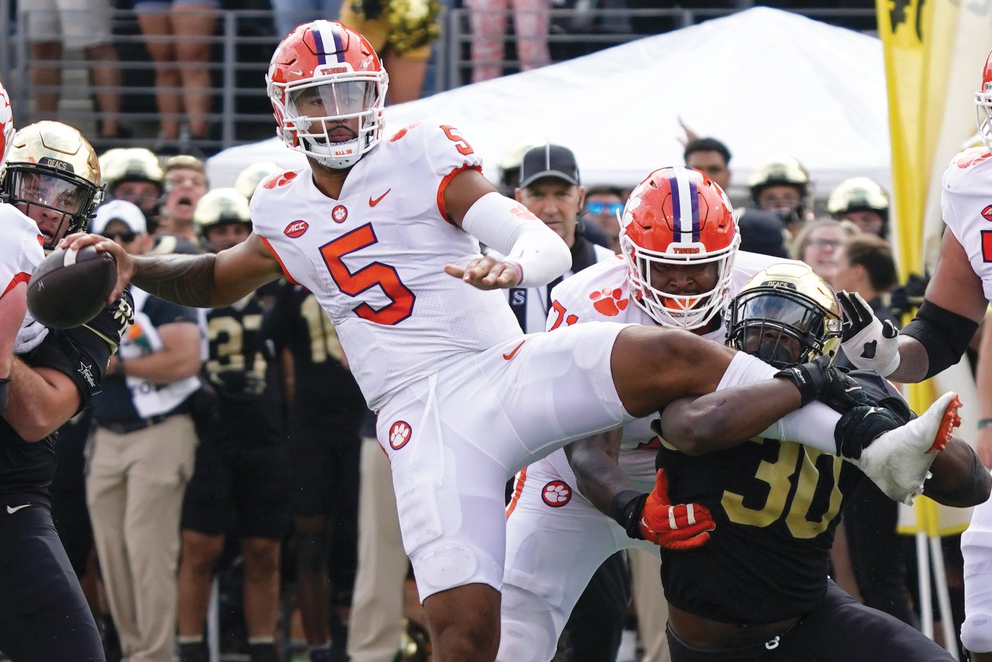 Clemson quarterback DJ Uiagalelei (5) looks to pass as Wake Forest defensive lineman Jasheen Davis (30) tries to tackle him during the Tigers' double-overtime win on Saturday.