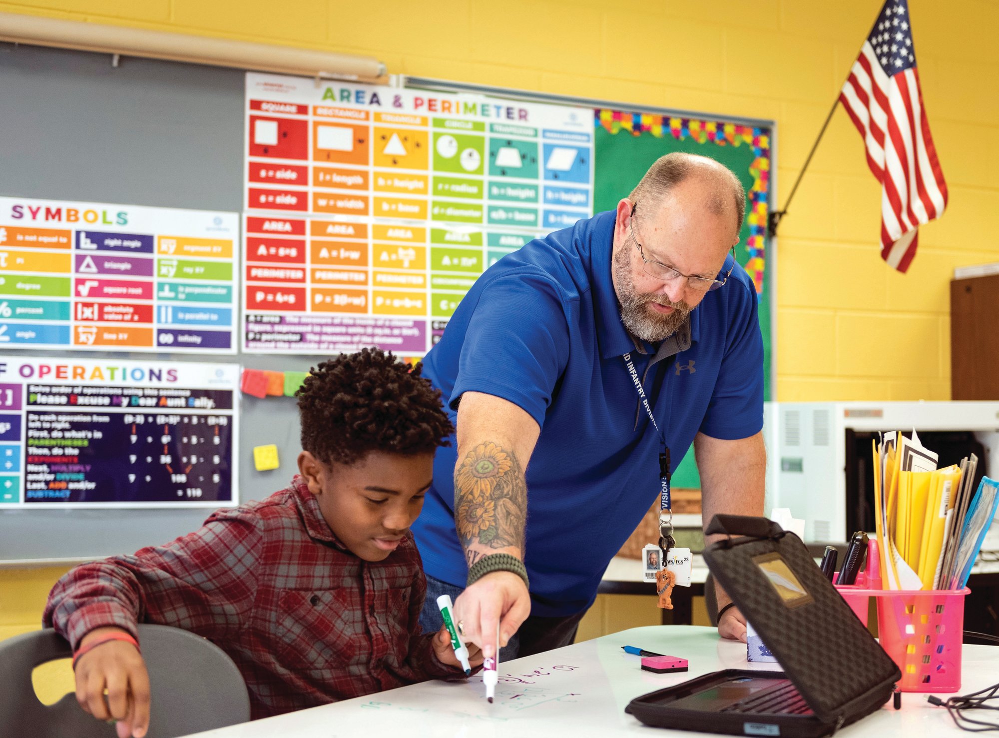 Retired U.S. Army veteran and teacher Christopher Simmons guides seventh-grader Elijah Williams through a math problem at Meadowlark Middle School in Winston-Salem, North Carolina.